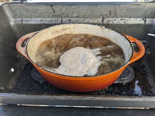 Maple sap boiling in a dutch oven in a bbq to evaporate down into maple syrup