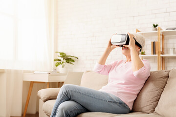 Senior Woman Experiencing Virtual Reality While Relaxing on Couch
