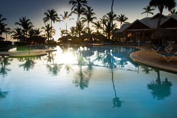 Fototapeta na wymiar Pretty swimming pool at sunrise in a large hotel in Punta Cana in the Dominican Republic