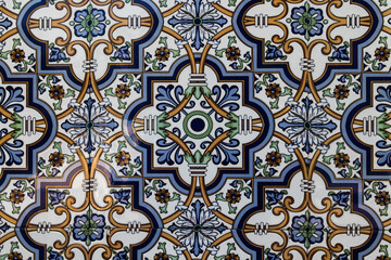 Tiles on the building exterior wall in Aveiro, Portugal. Abstract pattern with white, blue, orange and yellow colors. Symmetrical design.