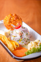Peruvian ceviche, accompanied by sweet potato, chili, corn cake.