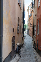 Sweden, traditional building, bike at narrow paved alley, Stockholm Gamla Stan Old Town. Vertical