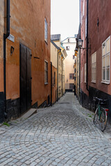 Stockholm Sweden, traditional building, lantern, bike at narrow alley, Gamla Stan Old Town. Vertical