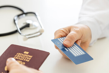 European health insurance card handed to doctor in doctor's office, Concept, Travel insurance, Holiday protection, Treatment abroad