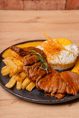 Poor style steak, potatoes and fried plantains, as well as white rice with its egg whipped with the yolk.
