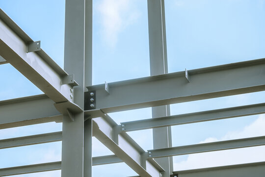 Mounting bolted connection of steel beams before welding. Metal construction covered protective gray primer.