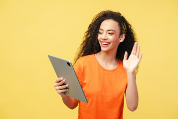 Curly haired girl, teenager holding digital tablet, waving hand, working online, having video call