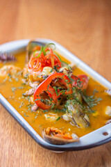 Parhuela or special seafood soup with crab, mussels and cassava, decorated with seaweed and served in a white bowl