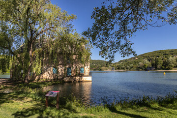 Fototapeta premium Chasteaux (Corrèze, Nouvelle aquitaine, France) - Vue printanière du lac du causse et de la maison de l'eau et de la pêche