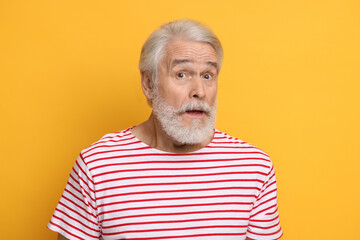 Senior man with mustache on orange background