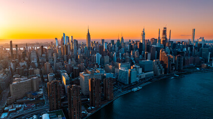 Orange light of setting sun illuminating the skyscrapers and high-rise buildings in New York...