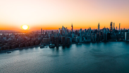 Orange light of setting sun illuminating the skyscrapers and high-rise buildings in New York...