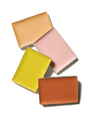 Different color correcting concealers on white background, top view