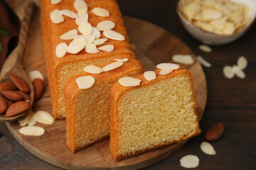 Cake with fresh almond flakes on wooden table, closeup