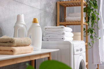 Soft towels, detergents, bench and washing machine indoors