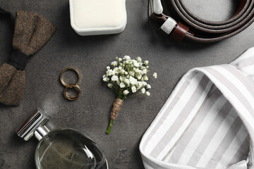 Wedding stuff. Flat lay composition with stylish boutonniere on black table
