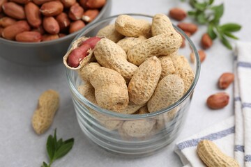 Fresh unpeeled peanuts on grey table, closeup