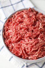 Raw ground meat in bowl on table, closeup