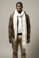 Obraz premium Studio portrait of smiling young African man wearing brown casual jacket and white scarf