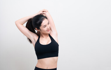 Attractive Asian woman in black workout clothes doing arm stretching on white background. Confident young female athlete body warm up before workout on isolated.
