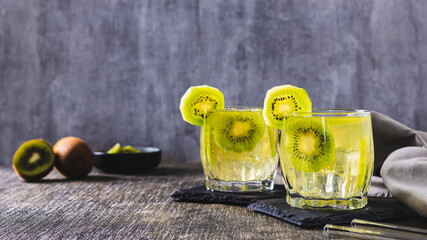 Summer cold mojito cocktail with kiwi in glasses on the table web banner