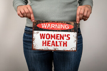 Women's Health Concept. Warning sign with text in a woman's hand