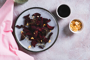 Pieces of baked beets with rosemary and garlic on a plate on the table top view