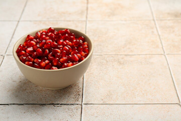 Tasty ripe pomegranate grains on tiled table. Space for text