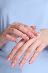 Woman applying cream on her hands, closeup