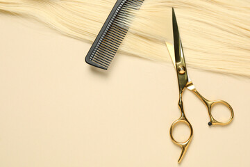 Professional scissors and comb with blonde hair strand on beige background, top view. Space for text