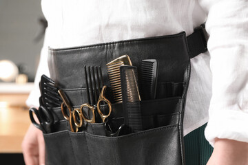 Hairstylist with professional tools in waist pouch in salon, closeup