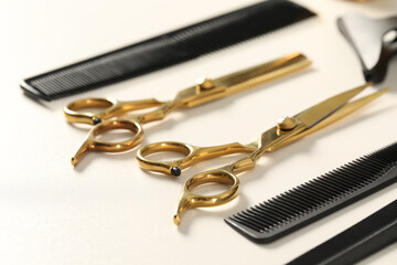 Hairdresser tools. Different scissors and combs on white table, closeup