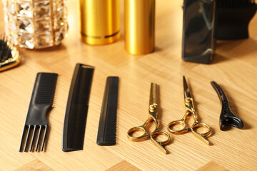 Hairdresser tools. Different scissors and combs on wooden table, closeup