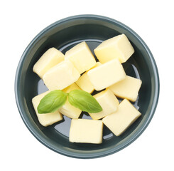 Tasty butter cubes and basil leaves in bowl isolated on white, top view