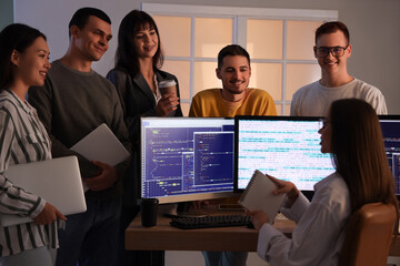 Team of young programmers working at office in evening