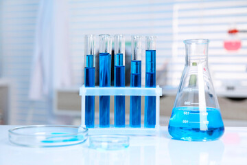 Laboratory analysis. Different glassware with blue liquid on white table indoors