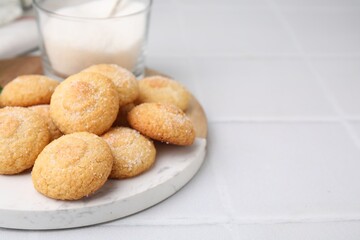 Tasty sweet sugar cookies and milk on white tiled table, closeup. Space for text