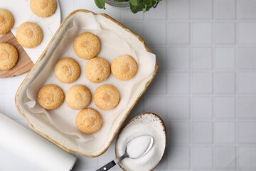 Tasty sweet sugar cookies in baking dish and mint on white tiled table, flat lay. Space for text