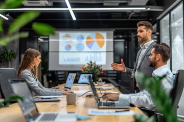 Confident man delivering a business presentation with a pie chart on a projector screen to colleagues