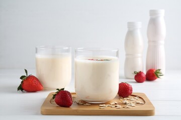 Tasty yogurt, oats and strawberries on white wooden table