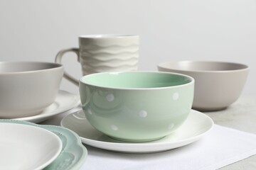 Beautiful ceramic dishware and cup on table