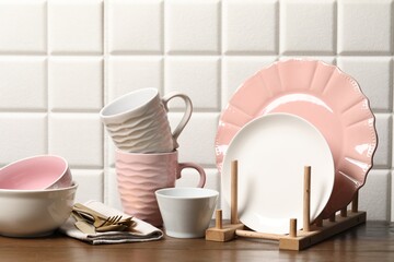 Beautiful ceramic dishware, cups and cutlery on wooden table