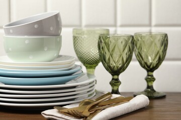 Beautiful ceramic dishware, glasses and cutlery on wooden table