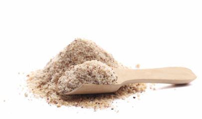 Hazelnuts ground pile in wooden spoon isolated on white, side view