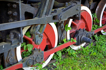 czerwone koła starej lokomotywy zarosniete zielem, koła stojącej na trawie lokomowtywy, zepsuta lokomotywa,  red wheels of an old locomotive on the lawn, wheels of a locomotive standing on the grass,  © kateej