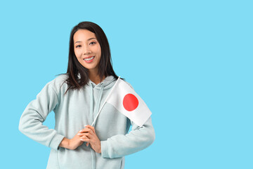 Young Asian woman with flag of Japan on blue background