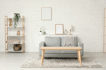 Interior of loft style living room with sofa, shelving unit and table