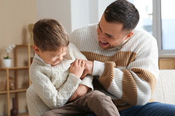 Happy father and his little son having fun together at home