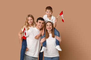 Happy family with flags of Canada on brown background