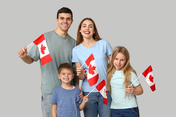 Happy family with flags of Canada on grey background
